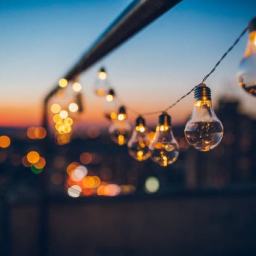 Close up picture of a string light bulbs at sunset on the rooftop.
